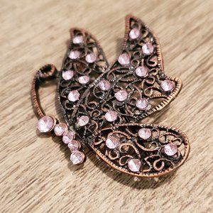 Woven bronze butterfly pin studded with pink rhinestones
